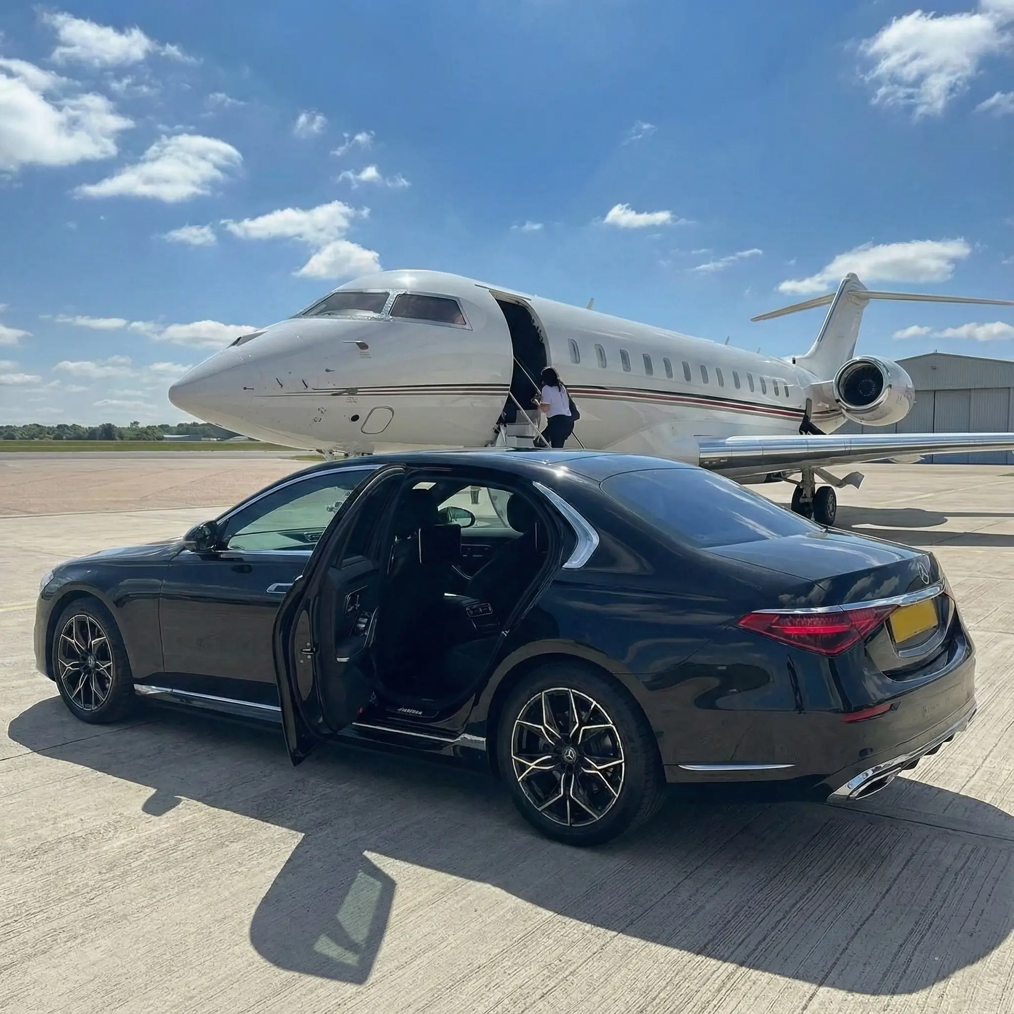 Luxury chauffeur car waiting by a private jet at Luton Signature